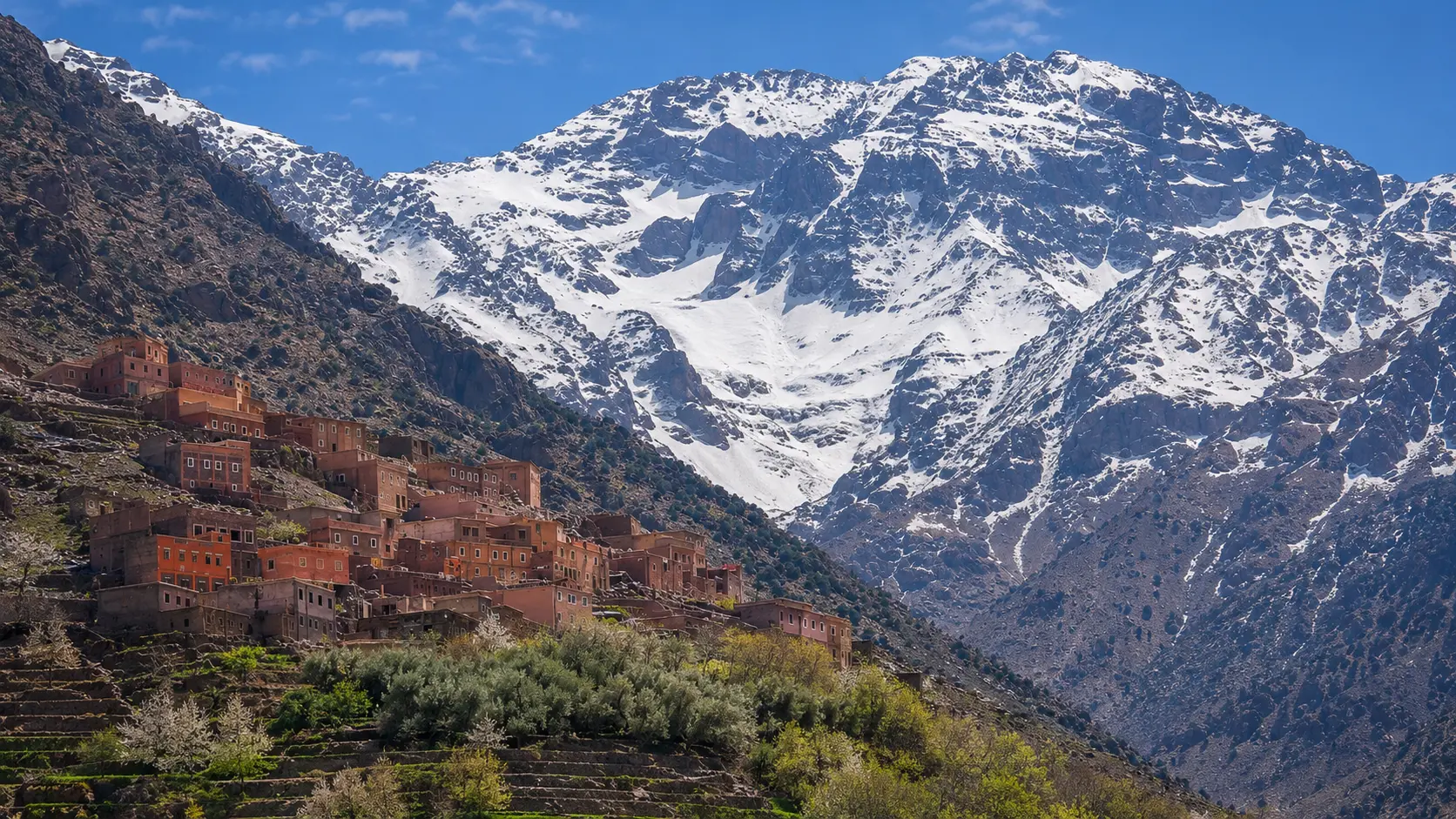 Snow-capped Mount Toubkal rising above Imlil village terraces in Morocco's High Atlas