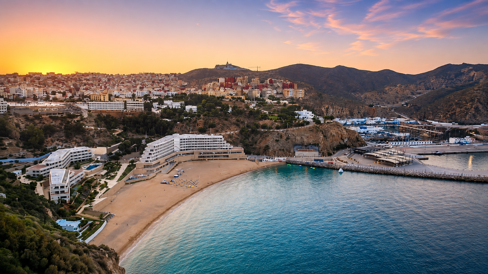 Quemado Beach below Al Hoceima at sunset, with the city, cliffs, port and Mediterranean water
